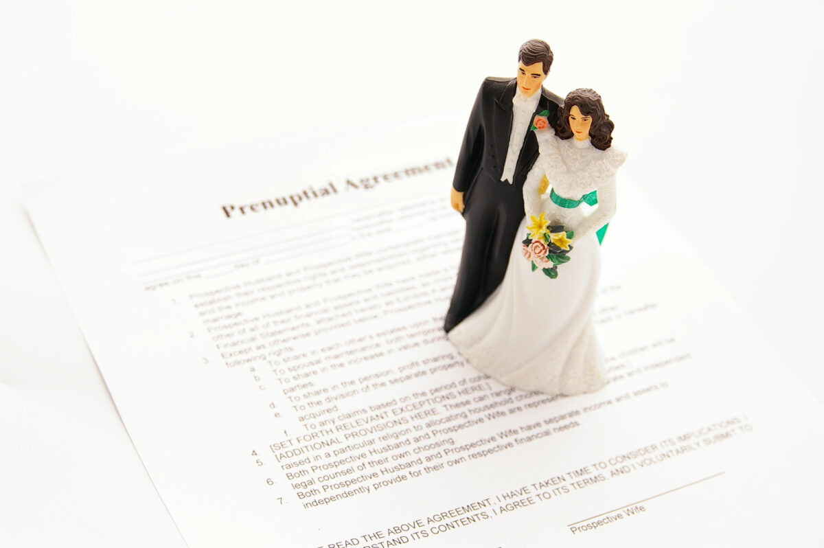 A newly married couple, bride and groom, standing on a prenuptial agreement